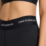 Calza deportiva New Balance Rise Sport Legging 25, color negro, de tiro alto con cintura elástica que lleva el logo de la marca repetido.
