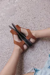 Sandalia de diseño minimalista con tiras anchas de neopreno color tostado, plantilla acolchada y base de goma antideslizante con costuras a la vista.