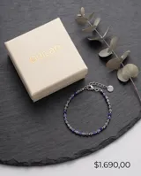 Pulsera elástica compuesta por pequeñas piedras naturales cúbicas de color azul profundo, intercaladas con cuentas metálicas plateadas.