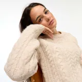 Sweater de punto con diseño trenzado, cuello redondo y mangas largas, de calce holgado y acabado texturizado.
