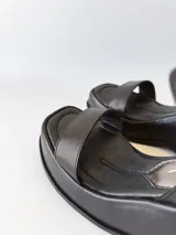 Sandalias negras de cuero con plataforma y pulsera al tobillo.