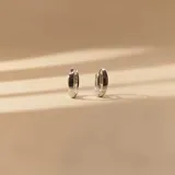 Aros tipo argolla pequeña en plata 925 con acabado satinado y detalle de tres pequeñas circonias incrustadas en el frente.