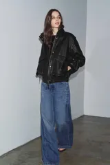 Chaqueta bomber de piel 100% color negro con efecto desgastado. Cuello alto, manga larga con cremalleras metálicas y bajo elástico. Bolsillos de plastrón con solapa y botón en el delantero. Cierre frontal con cremallera y botones a presión ocultos por solapa.