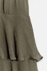 Vestido corto de cuello halter y escote en V, con diseño de múltiples volantes en capas y forro interior combinado a tono.