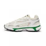 Championes Lacoste modelo L003 2K24, de diseño deportivo y urbano. Presentan una combinación de malla técnica y paneles sintéticos en tonos blanco y beige, con detalles en plateado. La suela destaca por su inserción en color verde vibrante y una base con relieve para mayor tracción.