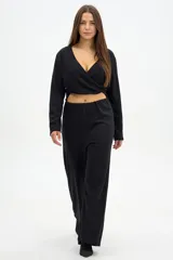 Pantalón tipo palazzo de tiro alto, color negro, con diseño de corte amplio y fluido. Confeccionado en tejido de poliéster con un sutil acabado brillante.