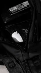 Riñonera negra confeccionada en cordura impermeable de alta resistencia. Presenta tres compartimentos principales con cierres metálicos, un bolsillo lateral adicional y una correa ajustable de alta densidad con broche de seguridad. Incluye una chapa metálica decorativa en el frente.