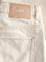 Jeans baggy de tiro bajo en color marfil, con diseño de pernera ancha y costuras pespunteadas a contratono.