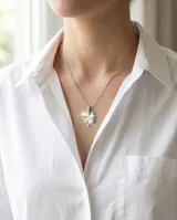 Collar de acero con dije en forma de trébol de cuatro hojas de acabado brillante.