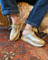 Zuecos deportivos color beige y blanco, con cordones y suela de goma.