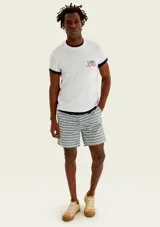 Remera blanca de corte regular y manga corta, con estampa frontal inspirada en un club de pesca en tonos azul y rojo.