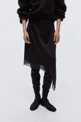 Pollera midi color marrón oscuro de punto, con cintura elástica y diseño asimétrico en el bajo adornado con detalle de encaje.