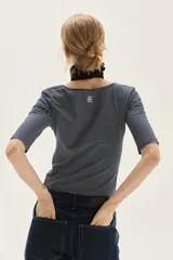 Remera de manga tres cuartos, corte ajustado al cuerpo, con escote redondo amplio. Presenta un patrón de rayas finas horizontales en tonos azul marino y blanco.