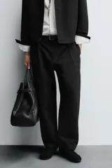 Pantalón de corte relaxed fit con pinzas delanteras, confeccionado en una mezcla de algodón, lino y lyocell. Presenta bolsillos laterales, bolsillos traseros de vivo y cierre frontal con cremallera y botón.