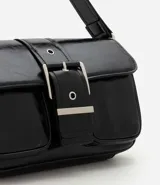 Cartera shoulder mediana Satinato de poliuretano color negro con acabado glossy, formato estructurado, tapa frontal con hebilla decorativa, bolsillos delanteros, asa regulable con hebilla y detalles de herrajes metálicos plateados.
