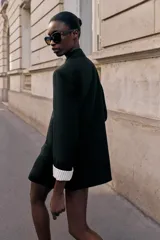 Blazer de lino color verde militar, con cuello solapa, hombreras y manga larga con puño revuelto con detalle a rayas. Cuenta con cierre frontal de un botón y bolsillos delanteros con solapa.