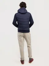 Chaqueta híbrida para hombre con frente acolchado de nylon y mangas de tejido de punto. Cuenta con cierre frontal, capucha y puños acanalados.