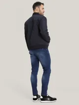 Campera estilo bomber acolchada de color azul marino, con patrón de costuras en rombos. Presenta cierre frontal de cremallera, cuello, puños y dobladillo en punto canalé oscuro. Incluye bolsillo utilitario con cremallera en la manga izquierda con cinta con el logo de Calvin Klein.