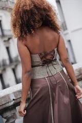 Corset strapless con escote corazón, confeccionado en una combinación de tela marrón lisa y tejido metalizado dorado con textura en la parte superior y en la cintura.