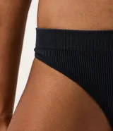 Bombacha de bikini hilo tipo vedetina, color negro, confeccionada en poliamida seamless con acabado texturizado de canalé y cintura ancha.