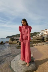 Pantalón palazzo color coral de lino con cintura alta y bolsillos laterales.