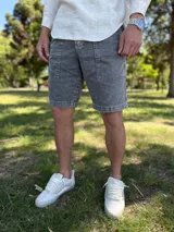 Bermuda de jean gris claro con efecto acid wash, bolsillos delanteros aplicados y costuras destacadas.