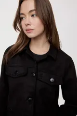 Campera negra de efecto gamuzado con cuello camisero, cierre frontal de botones, bolsillos plaqué en el pecho y detalles de costuras decorativas y calados.