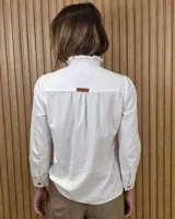 Camisa de denim negra con cuello mao y cierre frontal con botones. Cuenta con detalles de volados sutiles a lo largo de la botonera, costuras en contraste y frunces en los hombros.