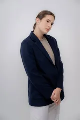 Blazer azul marino de baby alpaca con solapas de muesca, cierre frontal con un botón y bolsillos de parche.