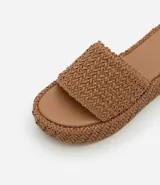 Sandalia tipo flatform con suela de plataforma plana y tira ancha superior, ambas con textura trenzada. Diseño sin cierre con puntera redonda.