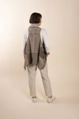 Chaleco sin mangas de lana fina sin teñir, color crudo, con cuello volcado y diseño a cuadros sutil. Presenta terminación a mano en crochet.