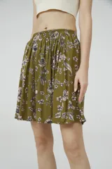 Minifalda verde militar con estampado floral en tonos rosados, con cintura elastizada.