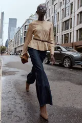Chaqueta de cuello redondo y manga larga con diseño peplum en el bajo. Confeccionada en tejido efecto ante, cuenta con cierre frontal de cremallera y cinturón fino ajustable en la cintura.