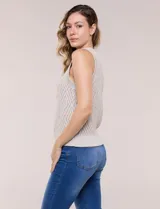 Chaleco tejido de punto calado melange, marca Elie Tahari, de color blanco. Presenta silueta semi entallada, escote a la base ligeramente elevado con terminación en punto acanalado, y sisas marcadas y ribeteadas en canalé. Confeccionado en tejido de punto con trama labrada y calados geométricos en forma de rombos, con espalda de tejido continuo y ruedo recto de largo a la cadera alta terminado en pretina ancha acanalada.