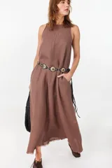 Vestido midi verde de lino italiano, con diseño sin mangas, cuello redondo y estampado de líneas onduladas punteadas. Cuenta con bolsillos laterales.