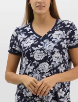 Camisón corto de corte recto y textura acanalada, color azul marino con estampado floreado en tonos celestes y blancos. Presenta mangas cortas y escote en V con aplicación de pequeños botones.