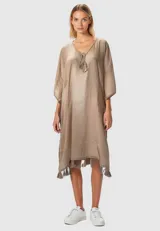 Túnica color beige de algodón, holgada, con cuello en V profundo, detalle de borlas y encaje en el ruedo.