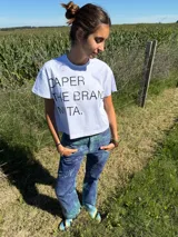 Remera blanca de algodón, de corte amplio y relajado, con cuello redondo y estampa gráfica frontal en color negro.