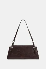 Bolso de hombro de formato alargado, color marrón oscuro con acabado ligeramente desgastado. El asa de hombro es delgada y ajustable mediante hebillas metálicas. Presenta detalles de tachas o remaches metálicos en los puntos de unión del asa.