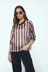 Remera de manga larga con tejido tipo mesh, diseño de rayas verticales en tonos marrones y blancos, cuello polo negro y puños tejidos con detalle de rayas.