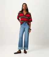 Pantalón de jean corte recto, color azul medio, con cintura alta, cierre tradicional de botón y cremallera, bolsillos funcionales y ruedo plegado en el bajo.