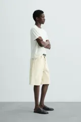 Camiseta relaxed fit de punto ligero color blanco hueso, con cuello redondo y manga corta. Acabados en rib.