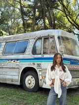 Camisa de lino blanca con mangas largas abullonadas y nudo frontal. Presenta un bordado artesanal en el pecho con diseño de sol y corazón en color rojo.