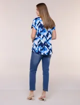 Blusa de silueta holgada y recta, confeccionada en crepe de poliéster con estampado animal print. Presenta escote redondo clásico, mangas cortas de hombro caído con puño doblado y ruedo ligeramente curvo.
