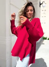 Sweater de punto color bordó, con diseño oversize, cuello redondo, mangas largas con puños acanalados y costura central vertical. Presenta un corte asimétrico con aberturas laterales en el ruedo.