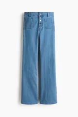 Jeans de tiro alto y corte acampanado, confeccionados en denim con leve elasticidad. Presentan cierre frontal con múltiples botones metálicos visibles, bolsillos de parche delanteros y diseño de perneras anchas desde la rodilla.