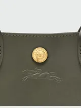 Bolso tipo tote en tamaño XS, confeccionado en cuero de color verde oliva. Presenta una estructura rígida, doble asa corta de mano y una correa ajustable y extraíble en tono beige. Incluye un cierre de botón a presión con el logo de la marca en el centro.