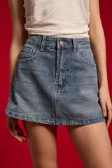 Minifalda de jean en color natural, con diseño recto, bolsillos y detalles de tachas en los laterales.