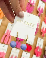 Aros colgantes con aro dorado y esfera celeste con textura.