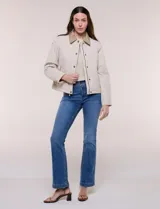 Campera acolchada capitoneada, marca Michael Kors, de color beige con cuello camisero de gamuza en contraste. Cuenta con cierre frontal de botones a presión metálicos, bolsillos laterales inclinados con ribetes de gamuza y mangas largas.